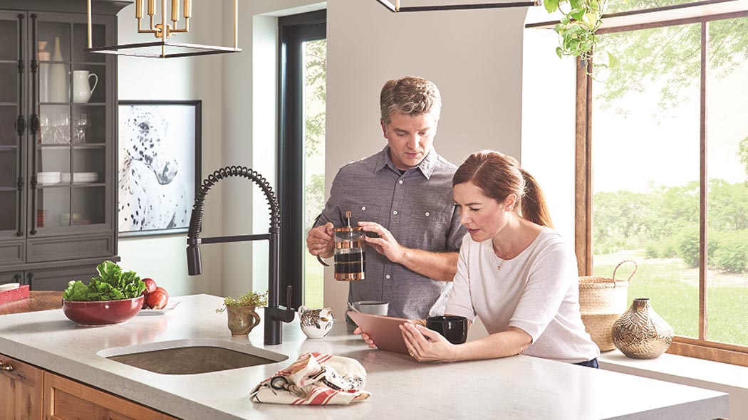 couple in kitchen scheduling appointment online with a bryant dealer