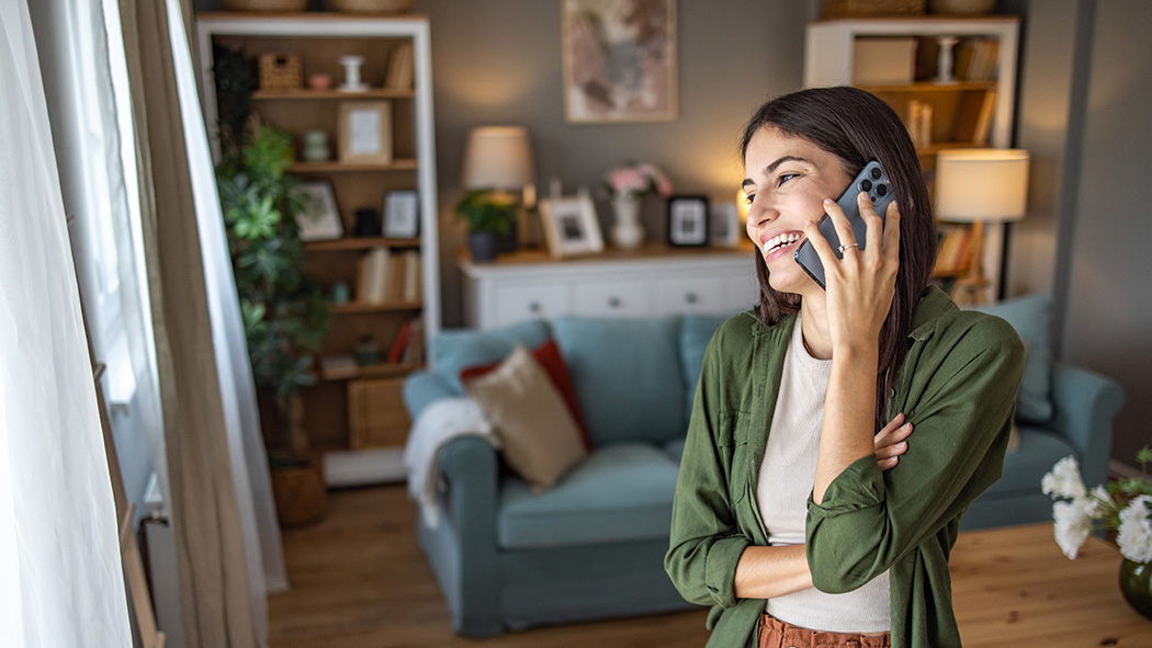 A woman talking on the phone scheduling emergency HVAC service